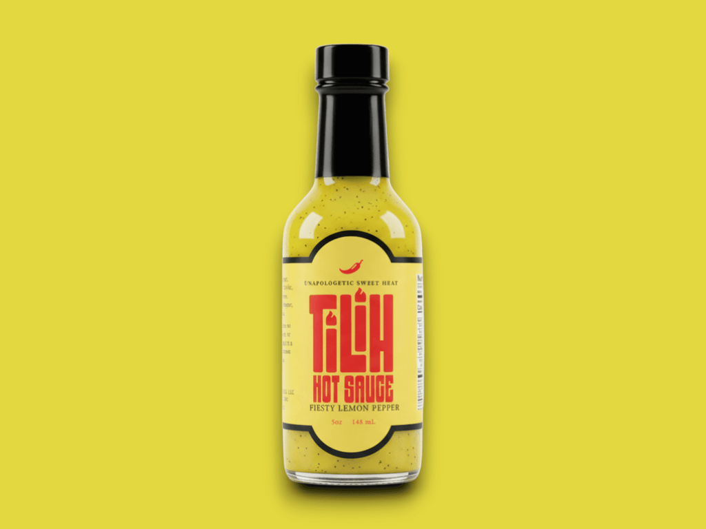 Close-up of Lemon Pepper Hot Sauce bottle on yellow background